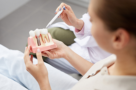 A person examining teeth with dental tools, likely in a dental office setting.